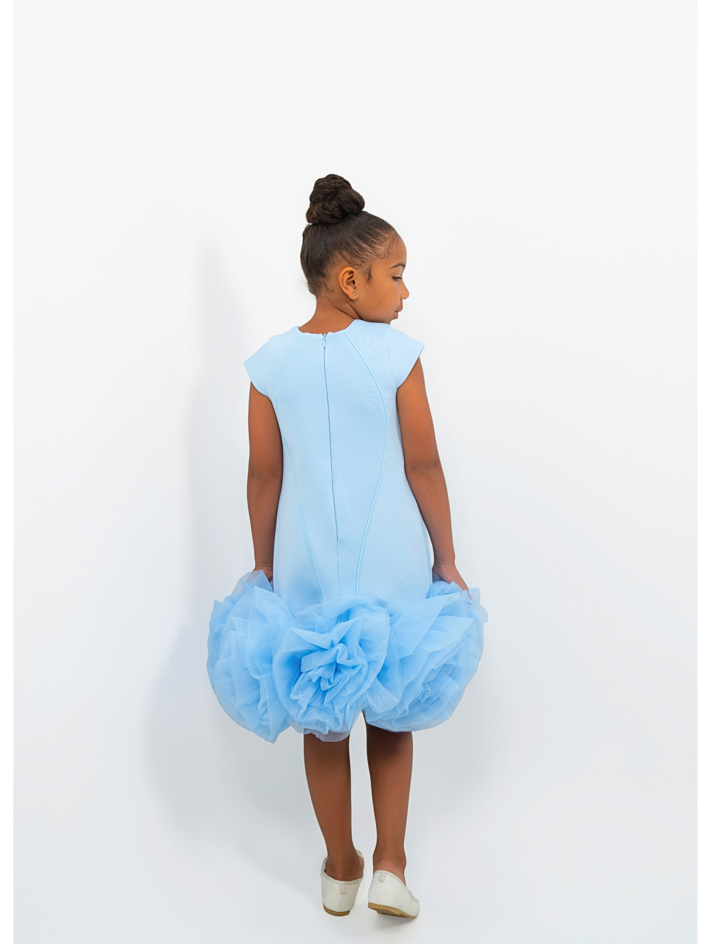 Girl wearing light blue puff-ball dress with keyhole neckline, ideal for birthdays or fashion shoots