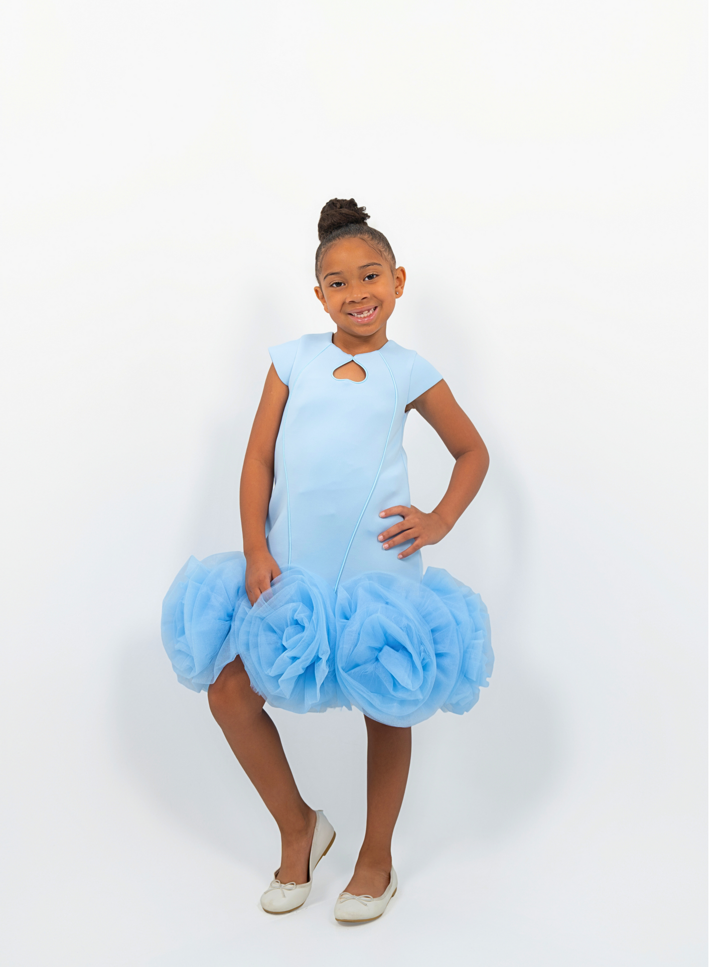 Girl wearing light blue puff-ball dress with keyhole neckline, ideal for birthdays or fashion shoots
