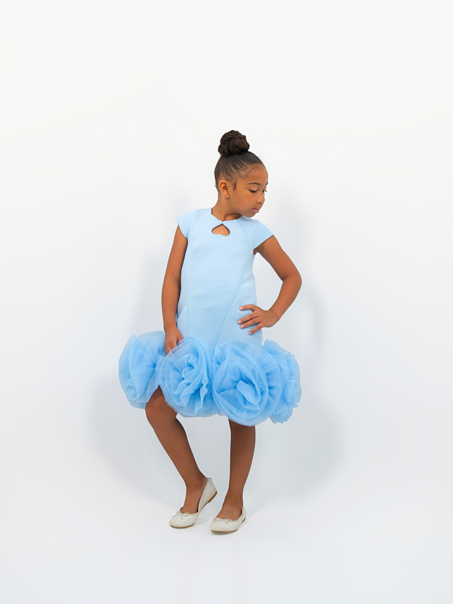 Girl wearing light blue puff-ball dress with keyhole neckline, ideal for birthdays or fashion shoots