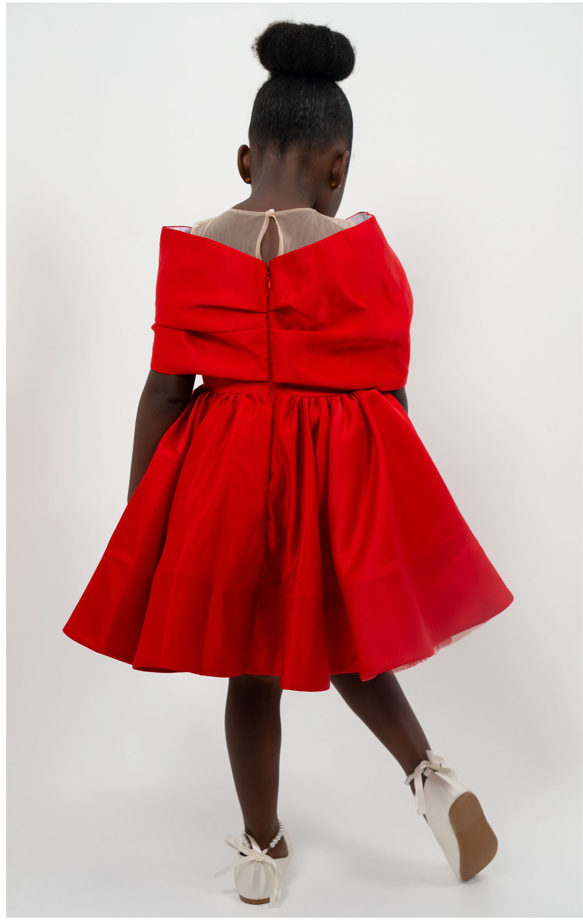 Girl in red satin dress with rhinestone bow, styled for Valentine’s Day or Christmas party