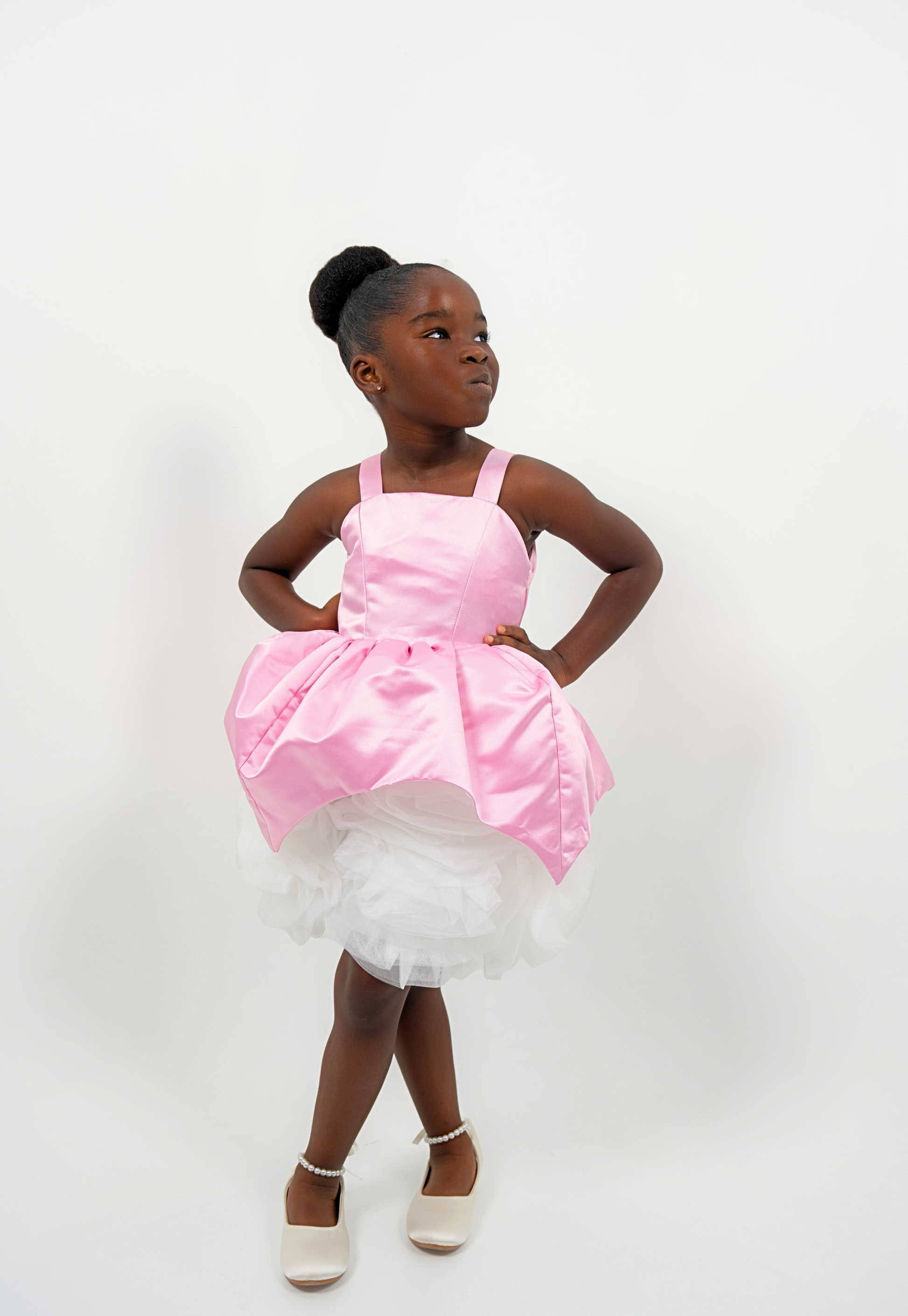 Girl wearing a pink satin princess dress with white tulle skirt, perfect for birthdays or weddings
