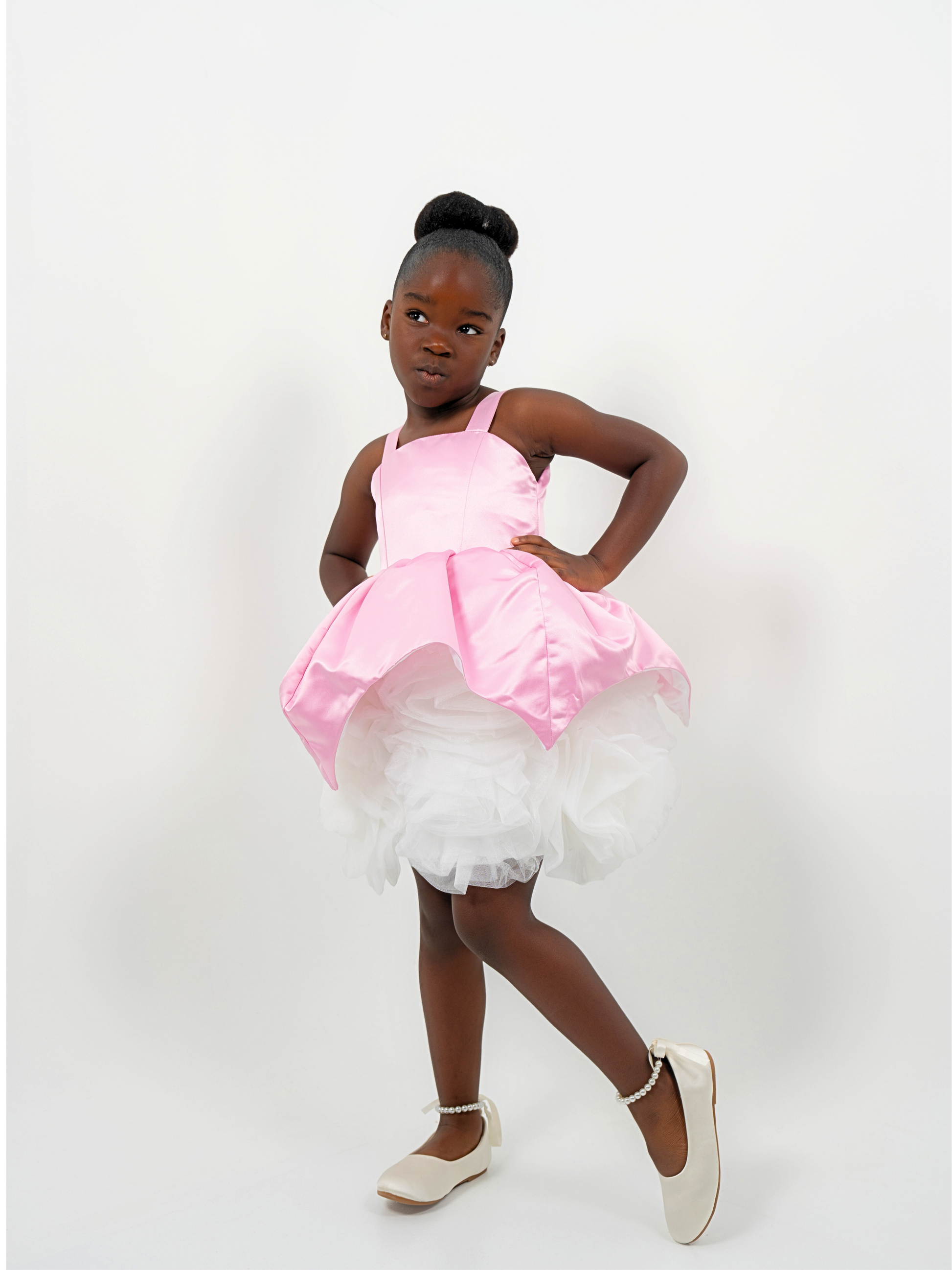 Girl wearing a pink satin princess dress with white tulle skirt, perfect for birthdays or weddings