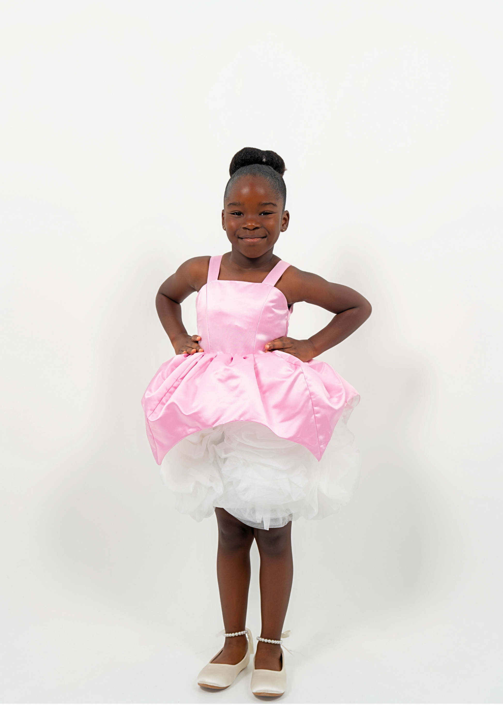 Girl wearing a pink satin princess dress with white tulle skirt, perfect for birthdays or weddings