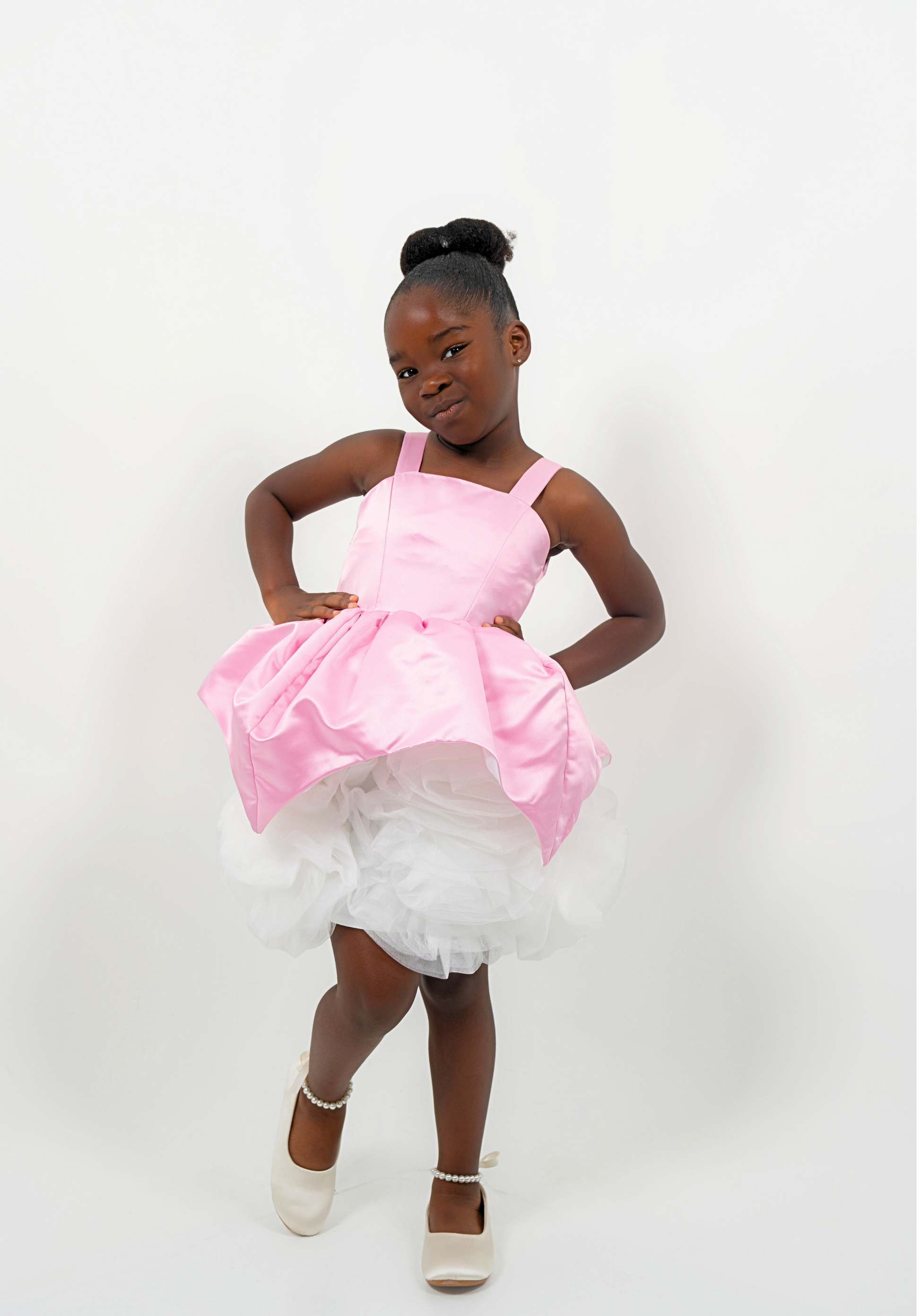 Girl wearing a pink satin princess dress with white tulle skirt, perfect for birthdays or weddings