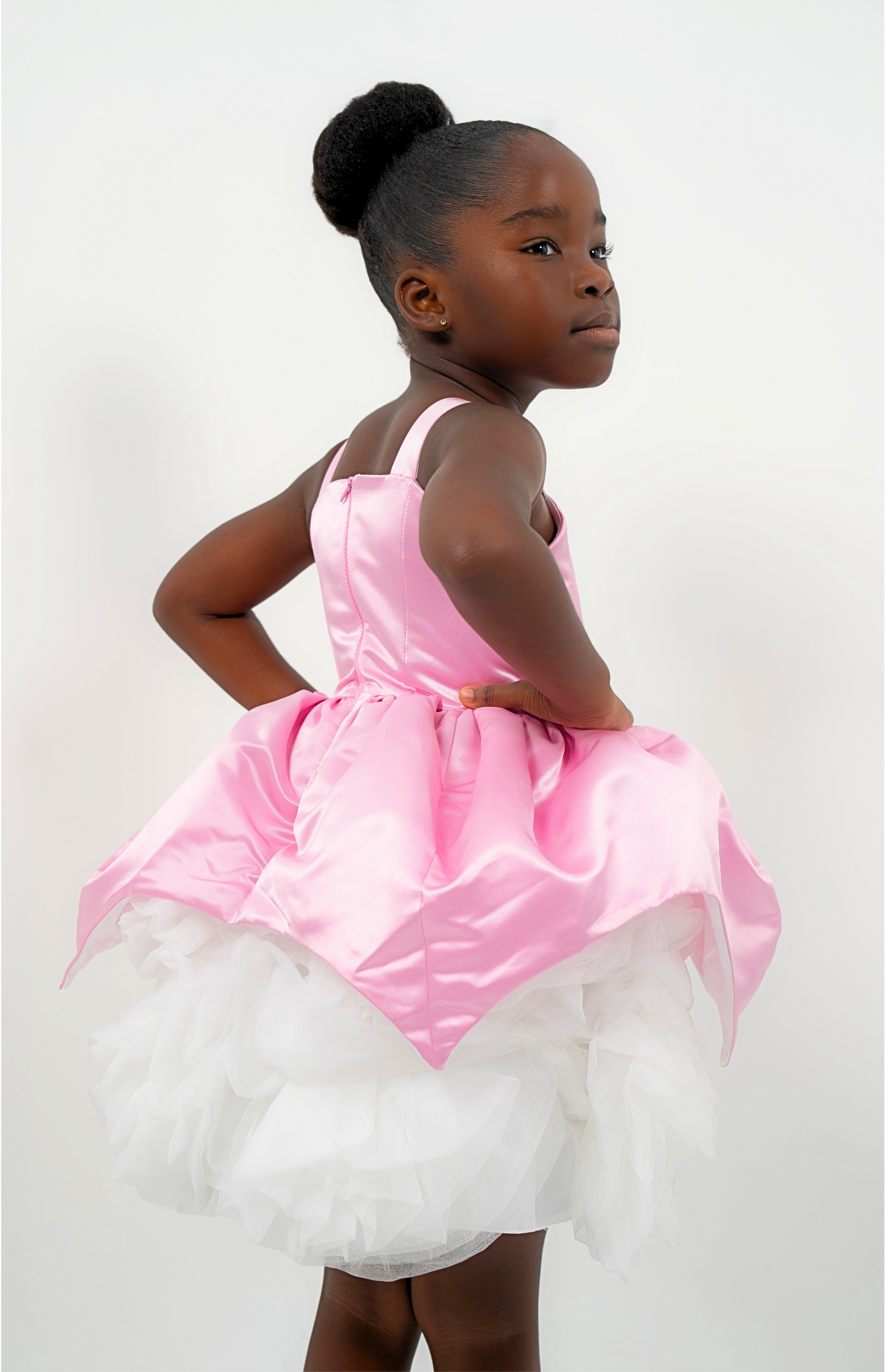 Girl wearing a pink satin princess dress with white tulle skirt, perfect for birthdays or weddings