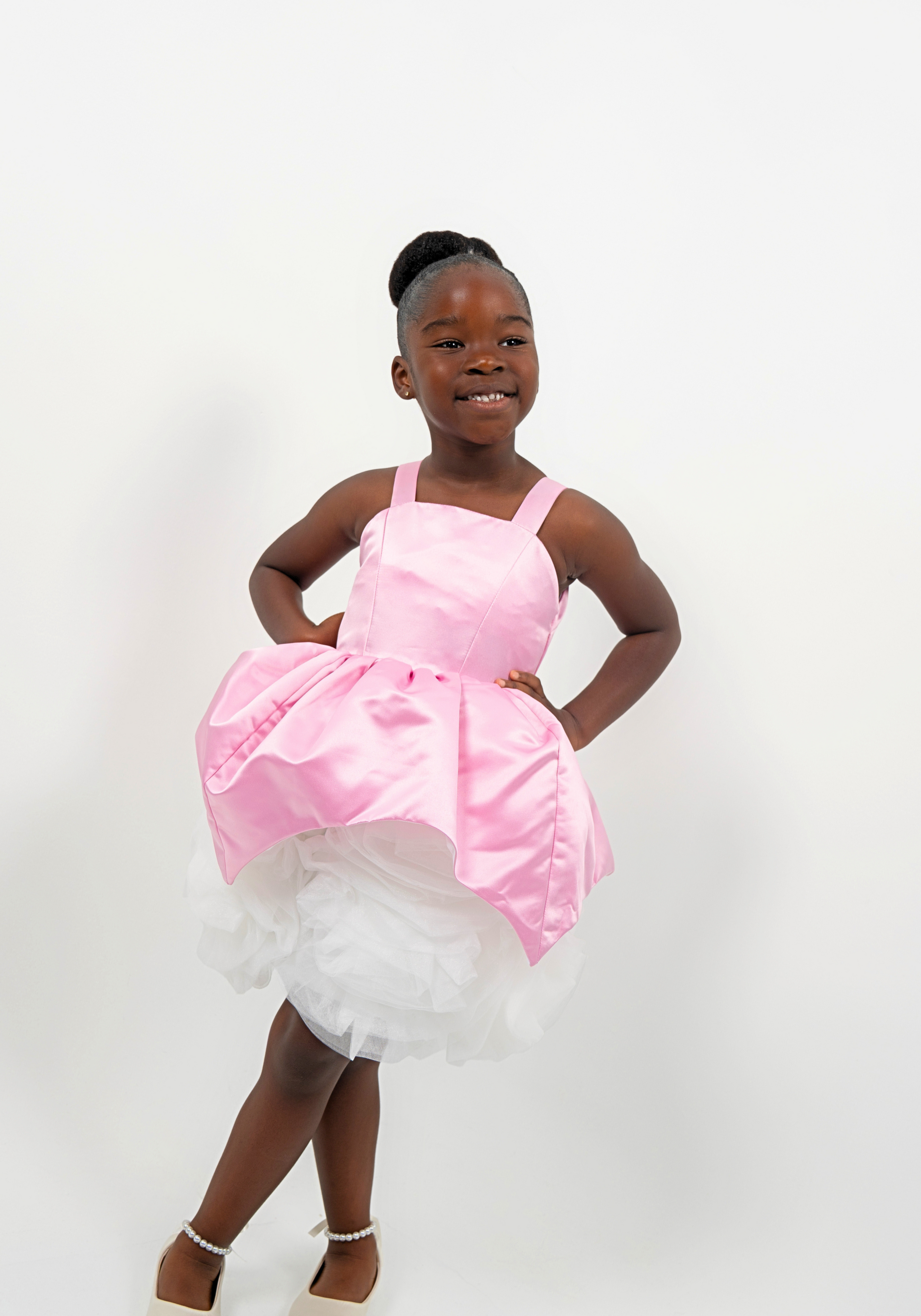 Girl wearing a pink satin princess dress with white tulle skirt, perfect for birthdays or weddings