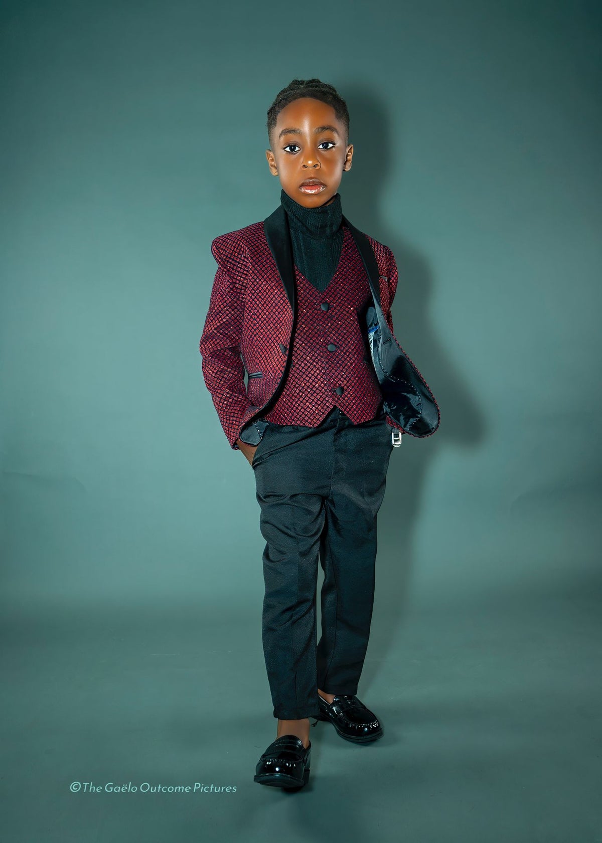 Original boy model wearing the burgundy shimmery five-piece tuxedo suit