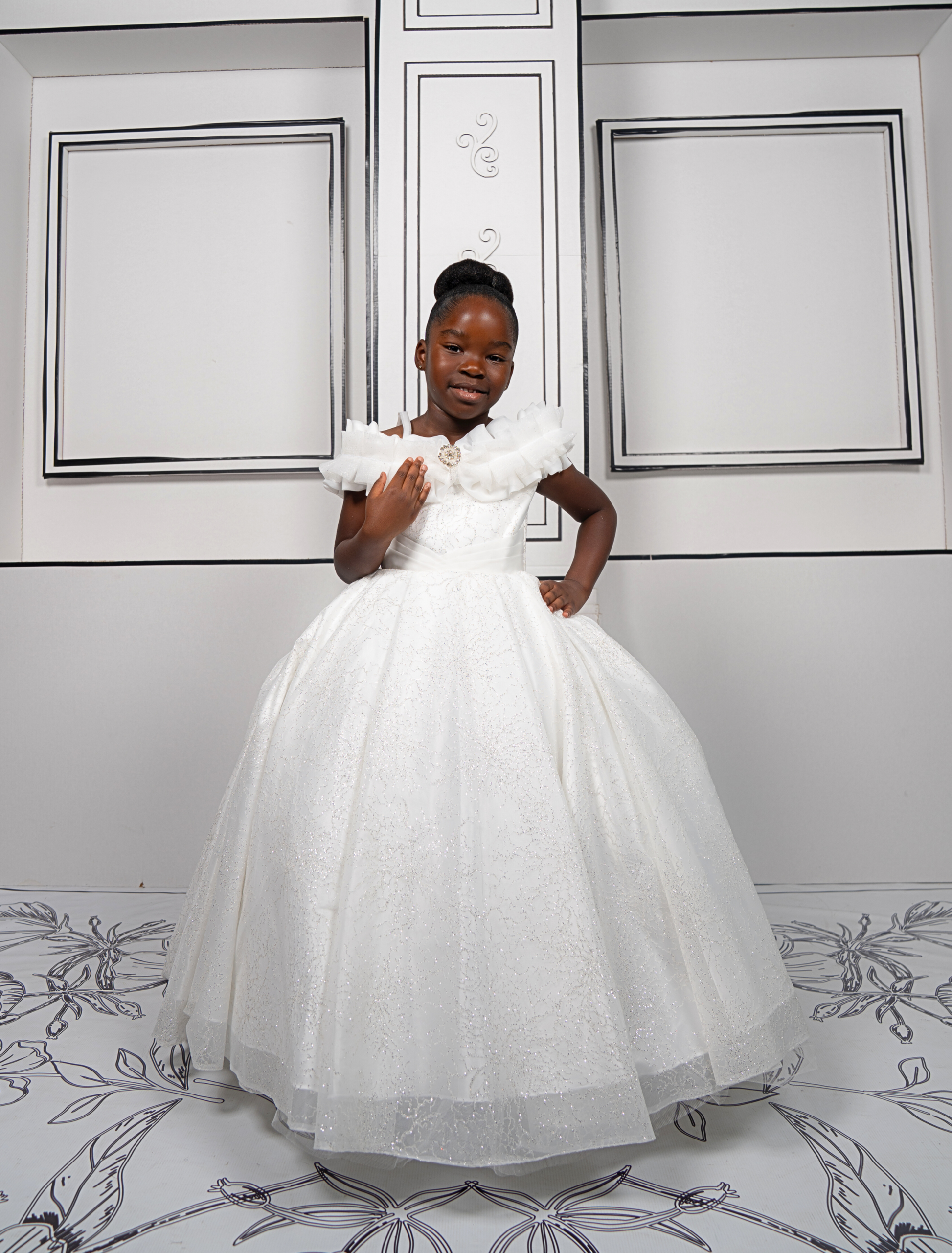 This elegant white ball gown is perfect for flower girls and little brides. With sparkly tulle and a dreamy silhouette, it’s a fairytale favorite.