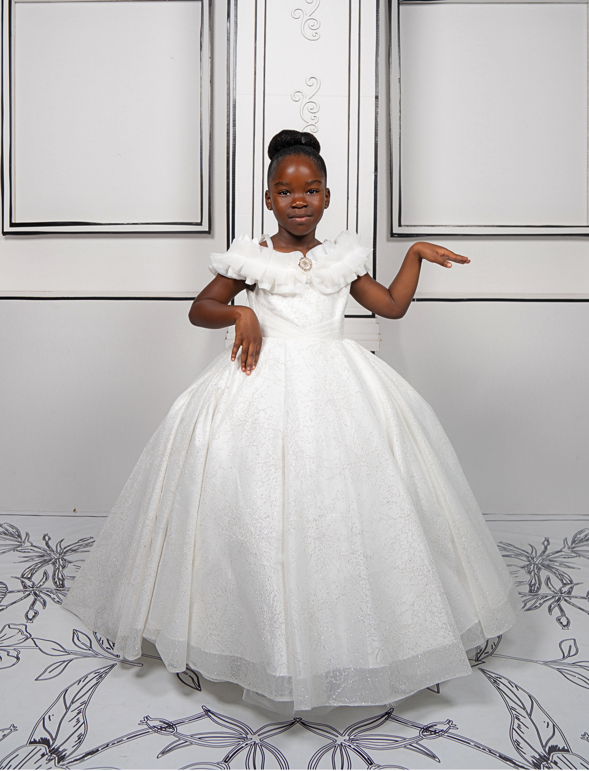 This elegant white ball gown is perfect for flower girls and little brides. With sparkly tulle and a dreamy silhouette, it’s a fairytale favorite.