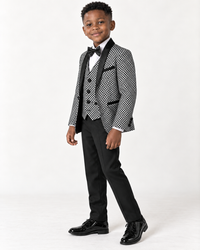 Black boy wearing black and white shimmery five-piece tuxedo, side-angle view