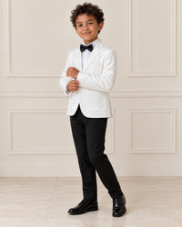 Mixed-race boy wearing the Boys White Velvet Stylish Blazer, angled view