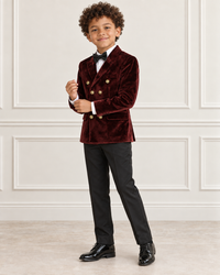 Mixed-race boy wearing the burgundy double-breasted velvet blazer, angled view