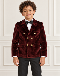 Mixed-race boy modeling the burgundy double-breasted velvet blazer, detail view