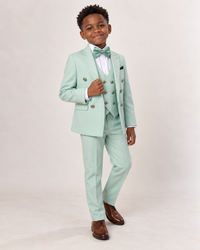 Black boy wearing mint green five-piece tuxedo, angled full-body view