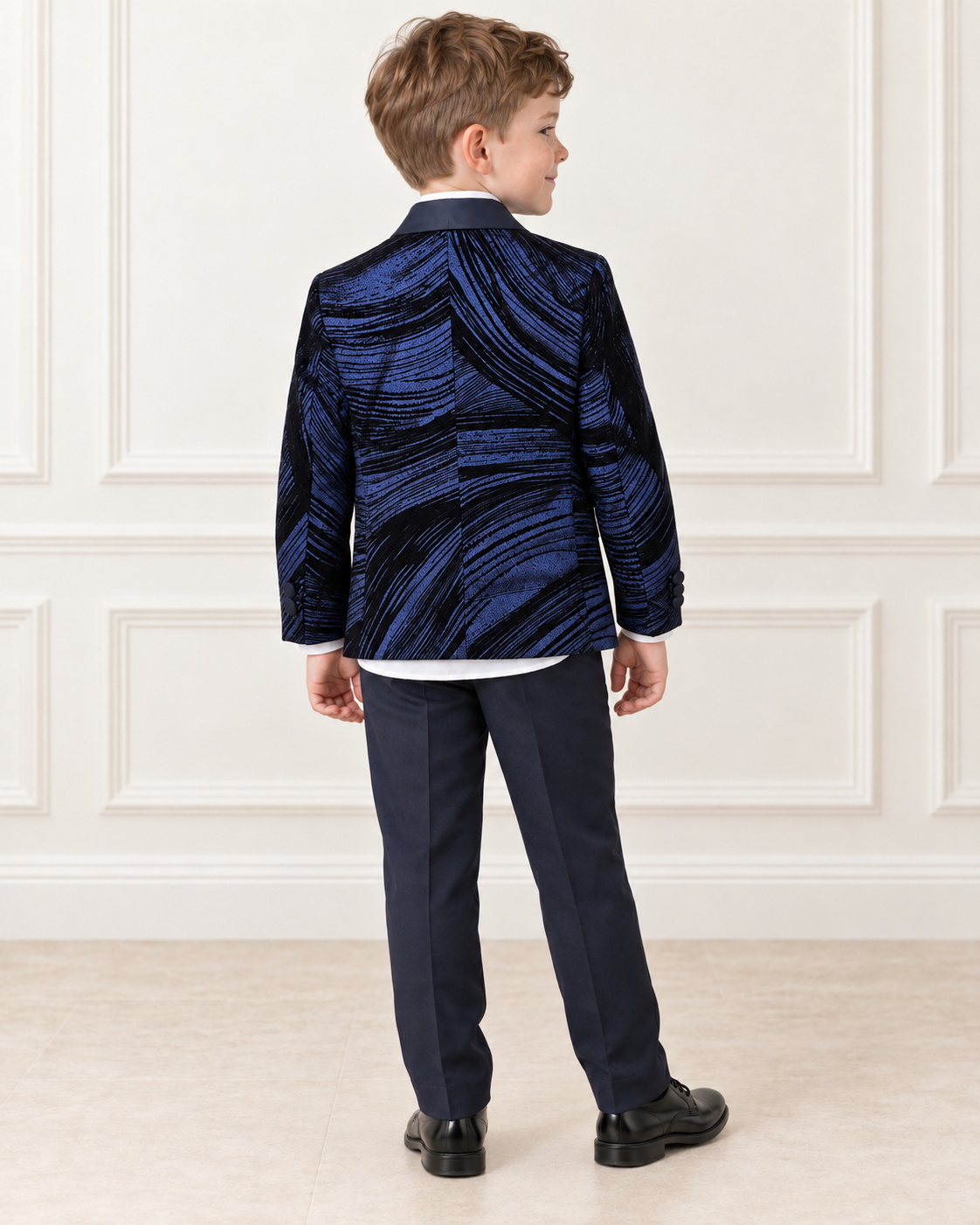White boy wearing navy blue shimmery tuxedo, back view