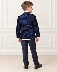 White boy wearing navy blue shimmery tuxedo, back view